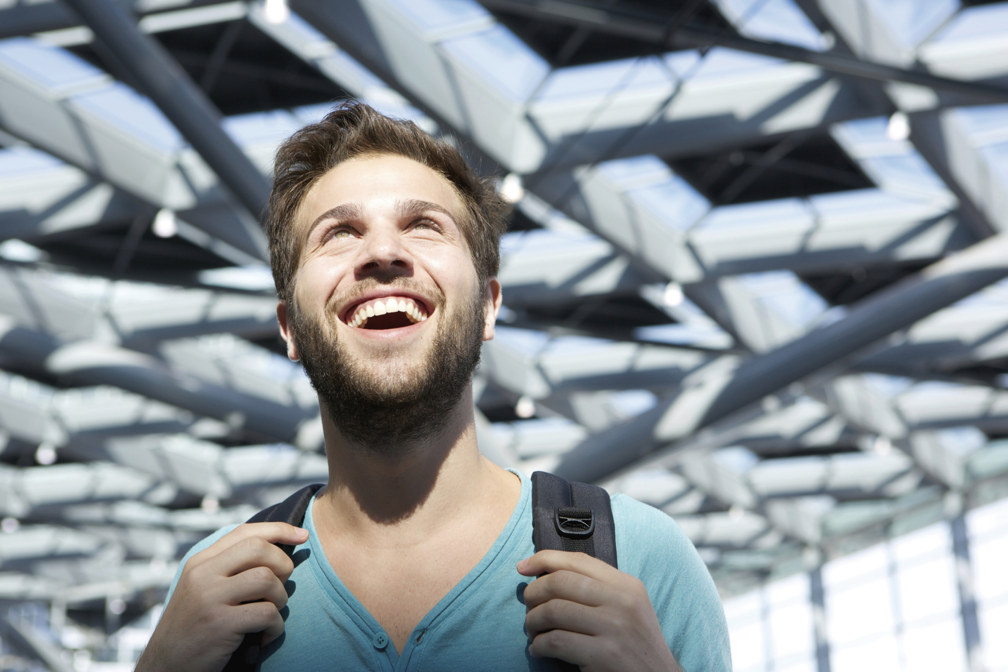 Im Fokus liegt ist ein junger lächelnder Student, der sich in einem ausergewöhnlichem Raum befindet